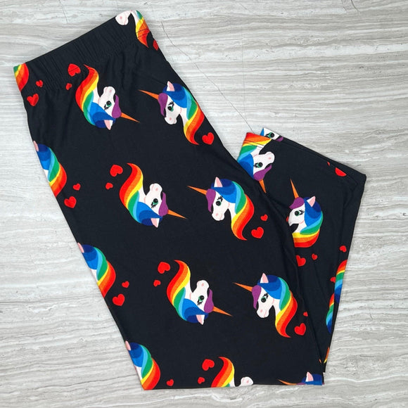 A pair of black capri-style leggings with a colorful unicorn and rainbow print, displayed on a flat surface.