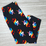 A pair of black capri-style leggings with a colorful unicorn and rainbow print, displayed on a flat surface.
